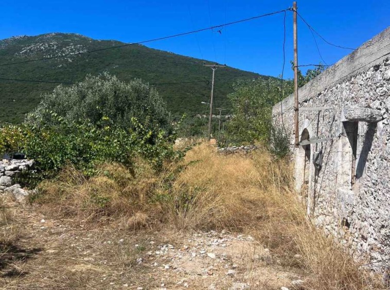 Quaint Fterno Village Stone House overlooking a stunning beach, capturing the essence of traditional Greek coastal living