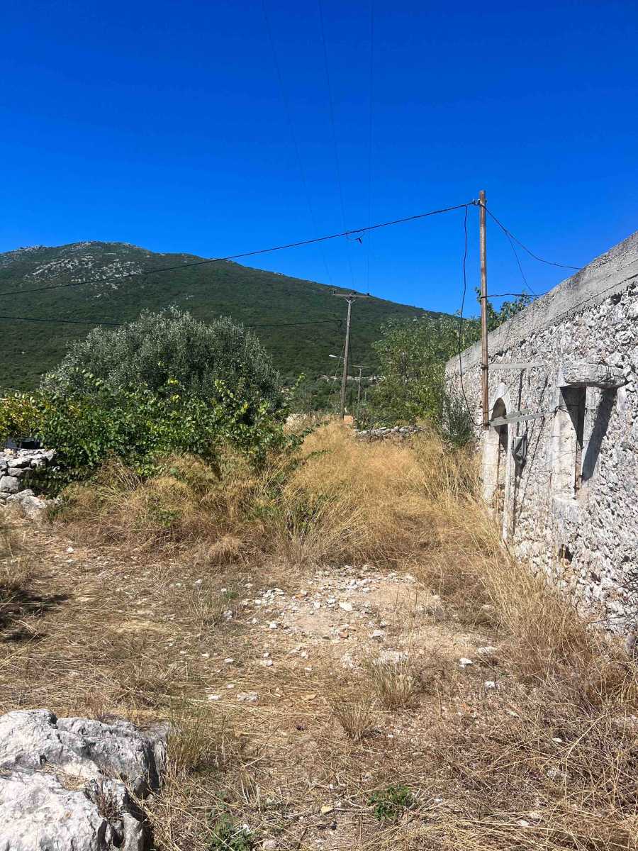 Quaint Fterno Village Stone House overlooking a stunning beach, capturing the essence of traditional Greek coastal living