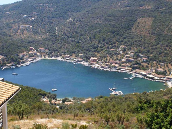 Aerial view of Sivota harbour in Lefkada, with boats docked in blue waters and surrounded by lush green hills, showcasing a potential real estate investment location.