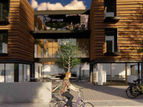 Modern multi-level residential building with wood facade, featuring balconies and large windows, with a person cycling in the foreground.